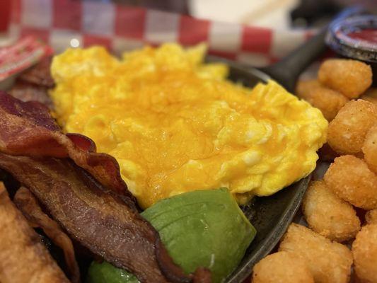 Breakfast platter, scrambled eggs with cheese. Crispy thick bacon