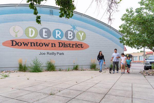 Image of the Downtown Derby mural in Commerce City with a family walking their dog