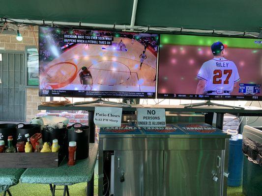 Outside patio area with TVs and a covered area