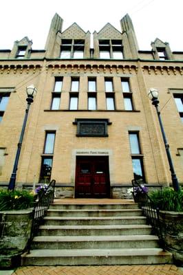 The plaque above the front door dates from the building's origin as one of the world's first Carnegie libraries.