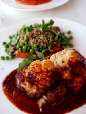 Cauliflower steak with roasted carrots, couscous and peas. Slightly spicy sauce