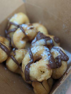 Fresh mini donuts with custom toppings. Nutella and powdered sugar.