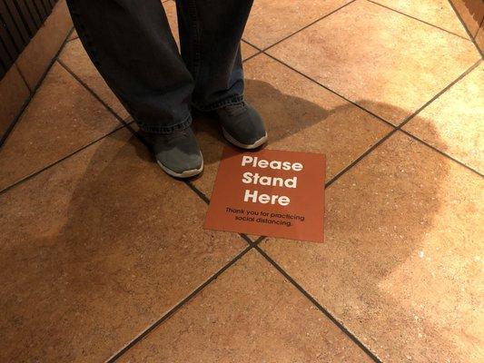 Floor signage for social distancing while standing in line.