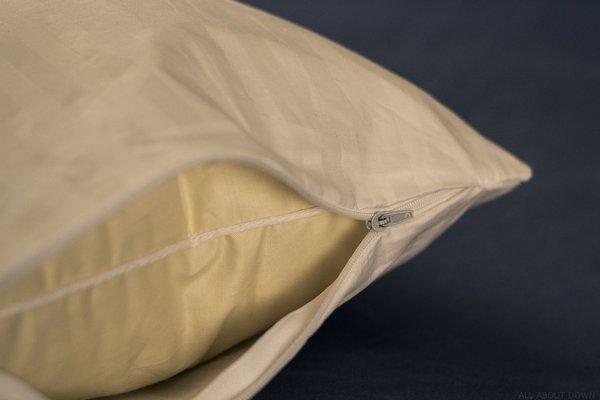 Zippered pillow protector on down pillow.