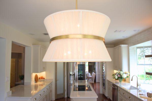 Unique Light fixture to connect the whole cream and gold kitchen.