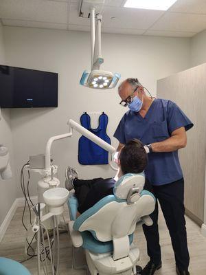 Ramin Rayhan, DDS examining the patient at Century Dentistry Center in Midtown Manhattan