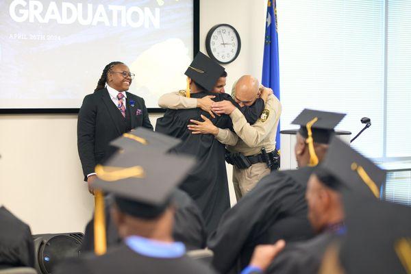 Officers embrace a graduated who has overcome obstacles in their life.