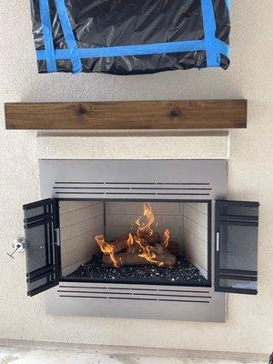 Gas logs with glass rocks with fireplace face cover glass accordion doors open