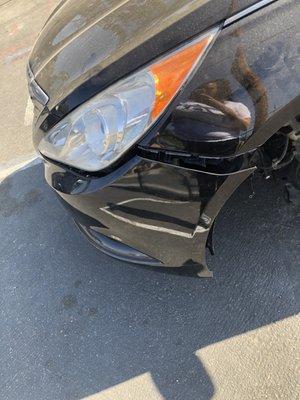 Pictures from the shop of my bumper hanging as it looked before the driver compromised the damages by banging it back into place