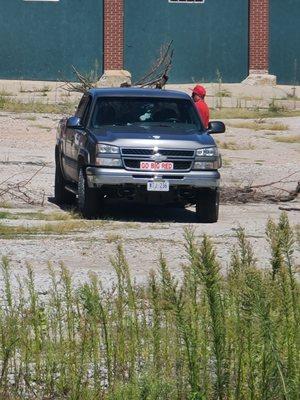 Mark J. White dumping brush in a business parking lot