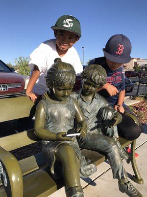 This sculpture is out in the parking lot. My kids wanted me to take a picture of them with the "fake kids" playing a game on his cell phone.