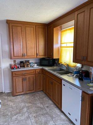 Cherry wood cabinets in a fruitwood finish with laminate countertop.