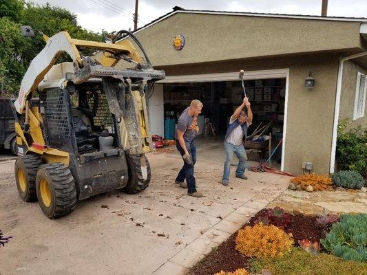 Here the guys are hammering the edges so as not to disturb the beautiful landscaping with the machine.