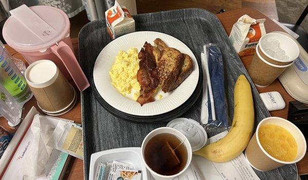 French toast, bacon, scrambled eggs, orange juice, banana and tea