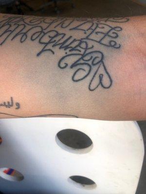 A horrible ink bleed from an upside down ugly tattoo