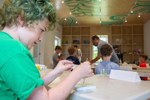 Child working on project during one of our summer camps in the Courtney Blossman Art Cottage.