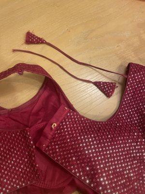 Poor quality broken clasp to hook blouse together and broken tie for top of lehenga blouse.