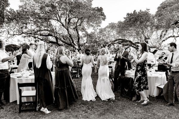 two brides enter wedding reception