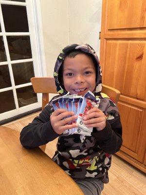 A happy boy with his unopened packs of cards.