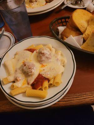 Rigatoni and meatballs with cheese and garlic bread.