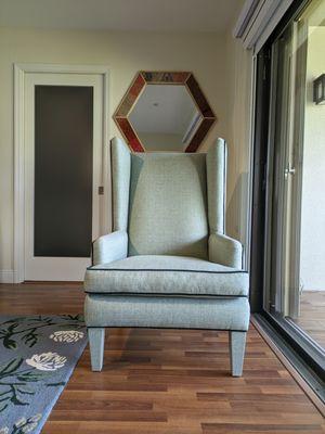 Wing chair reupholstered in green linen with matching dark green velvet piping from our fabric selection.