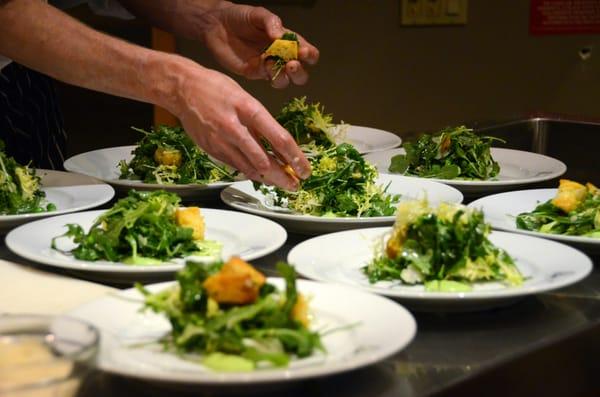 Plating the salad course.