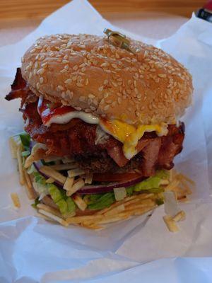 Brazilian xtudo burger egg,bacon, lettuce  ,tomato, onions potato chips, mayo ,ketchup,  mustard , extra cheese on a sesame seed bun.