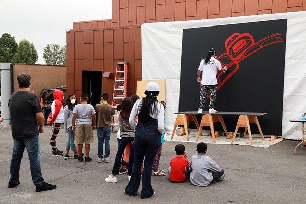 Visiting artist Corey Stein painting "Raven Traveling" with spray cans