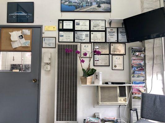 Wall of certificates, awards, and a TV