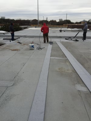 Our workers are repairing a leak in a modified bitumen roof in very cold weather.