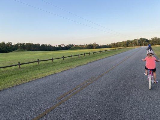 Riding our bikes on main road past 2 mounds