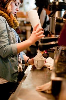 Adding the homemade whipped cream to a mocha.