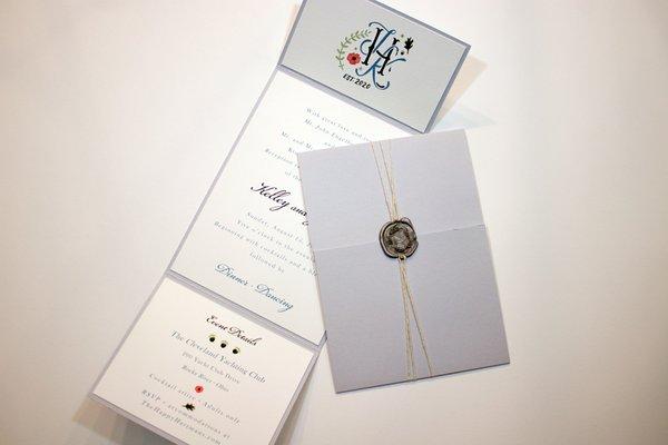 Tri fold wedding invitation suite with custom logo, wax seal and string cording wrap.