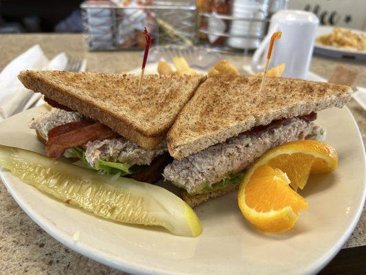 Tuna salad sandwich on wheat with added avocado and bacon