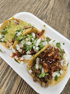 Carnitas with creamy mild green salsa, Adobado in the middle with no salsa needed, and Asasda with hot chile, which it needed.