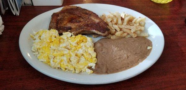 Pork Chop, Scrambled Eggs, Potatoes, and Refried Beans