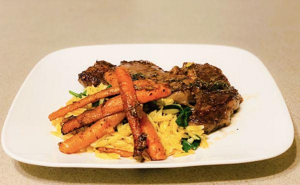 Organic grass fed rib eye with organic baby carrots and truffle spinach orzo