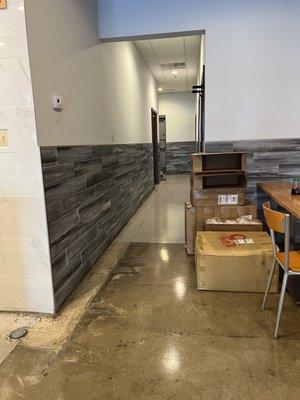 Boxes in the dining area, clutter in the back.