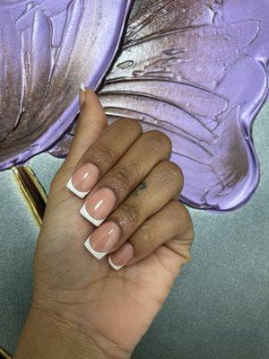 Short, white French tip nails.