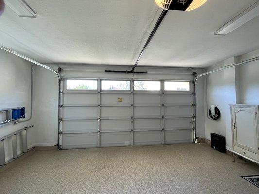 Power for Tesla Wall Connector ran across ceiling of garage. Panel is located on other side of garage on the left.