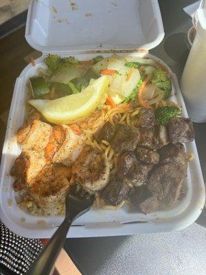 Combination plate. Steak and shrimp with rice, noodles and veggies