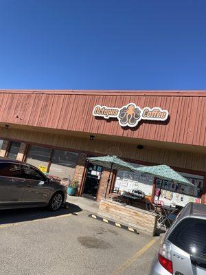 Front of shop, outside seating area with shade and the coolest logo