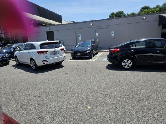 Dealership Service Dept., employees BLOCKING HANDICAPPED PARKING AND USING THE HANDICAPPED ACCESS LANE TO CHARGE ELECTRIC/HYBRID VEHICLES...