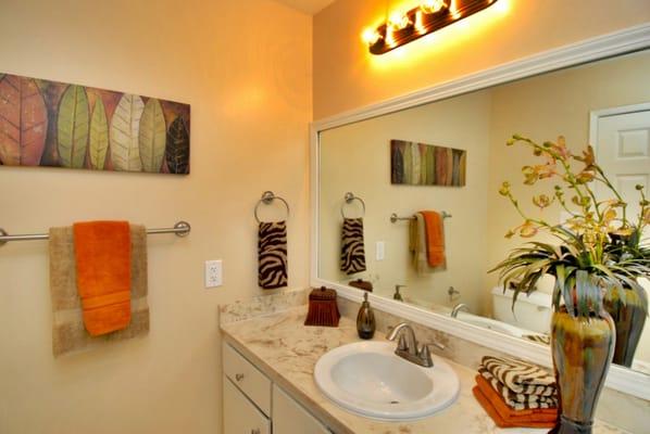 Even dated bathrooms benefit from staging.  Buyer's eyes are drawn to the accent pieces as opposed to the dated bathroom cabinet.