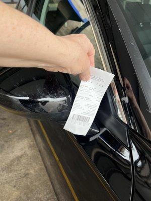 Receipt with right mirror covered in bug gunk after wash at Quik's Car Wash