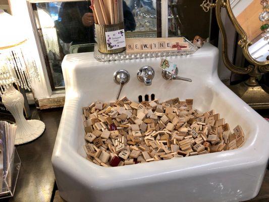 Scrabble wood pieces in a sink