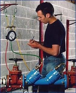 A technician testing a backflow prevention device