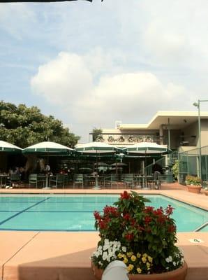 View of the pool. Dining tables and restaurant behind