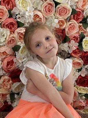 Happy little girl loving the flower wall