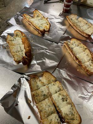 Yummy garlic bread in buttery seasoned garlic sauce on a long hard roll.